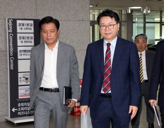 대통령직속 국정기획위원회 이한주(오른쪽) 위원장이 18일 정부세종컨벤션센터에서 열린 경제1분과 기획재정부 업무 보고장에 입장하고 있다. 왼쪽은 조승래 국정기획위 대변인.<연합뉴스 사진>